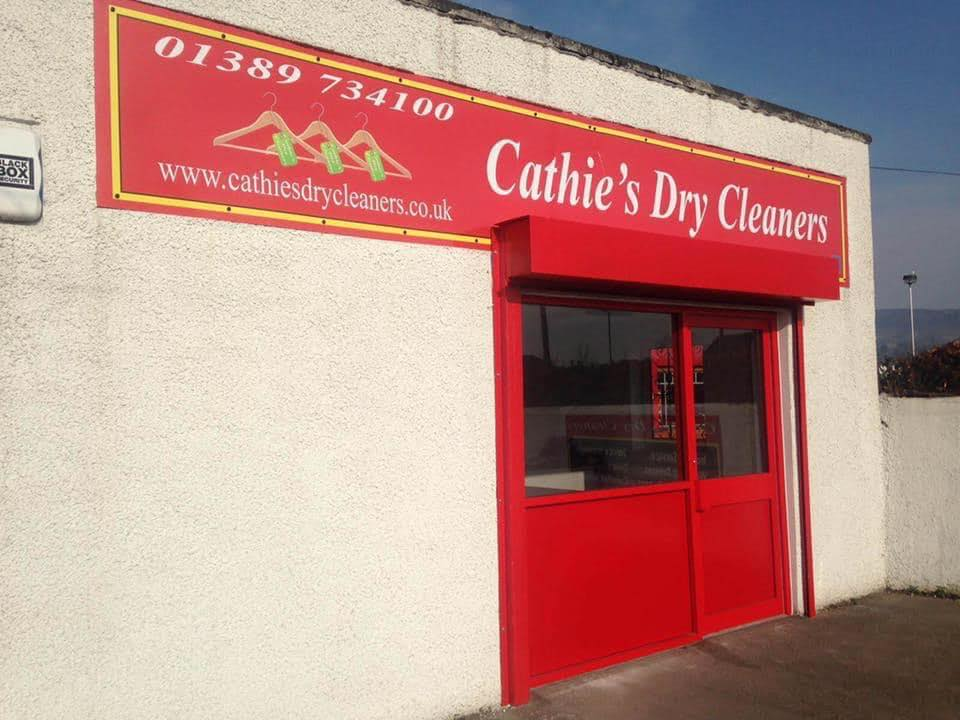The Cathie's Dry Cleaners shopfront on Glasgow Road, Dumbarton, with its red and yellow sign and red shop door.